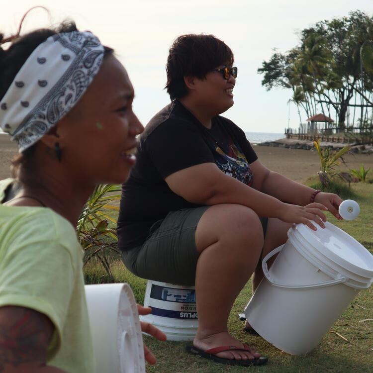 FJK and Amy Dangin happily drumming repurposed paint buckets at the beach.